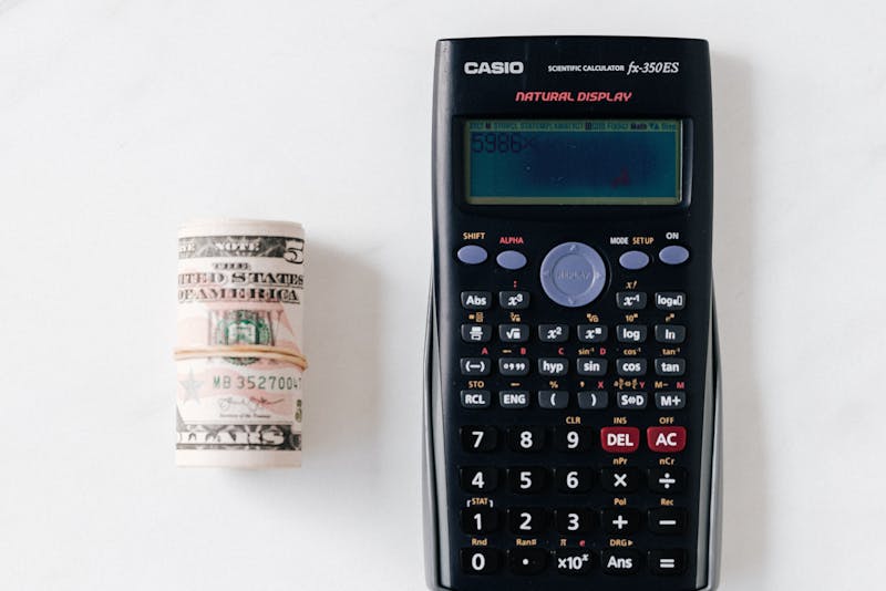 a calculator and a bundle of cash